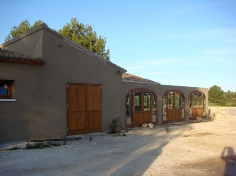 The first El Campo, 2008: a stone-coloured building with three arched wooden doors on a dry hillside above Jávea, Spain.
