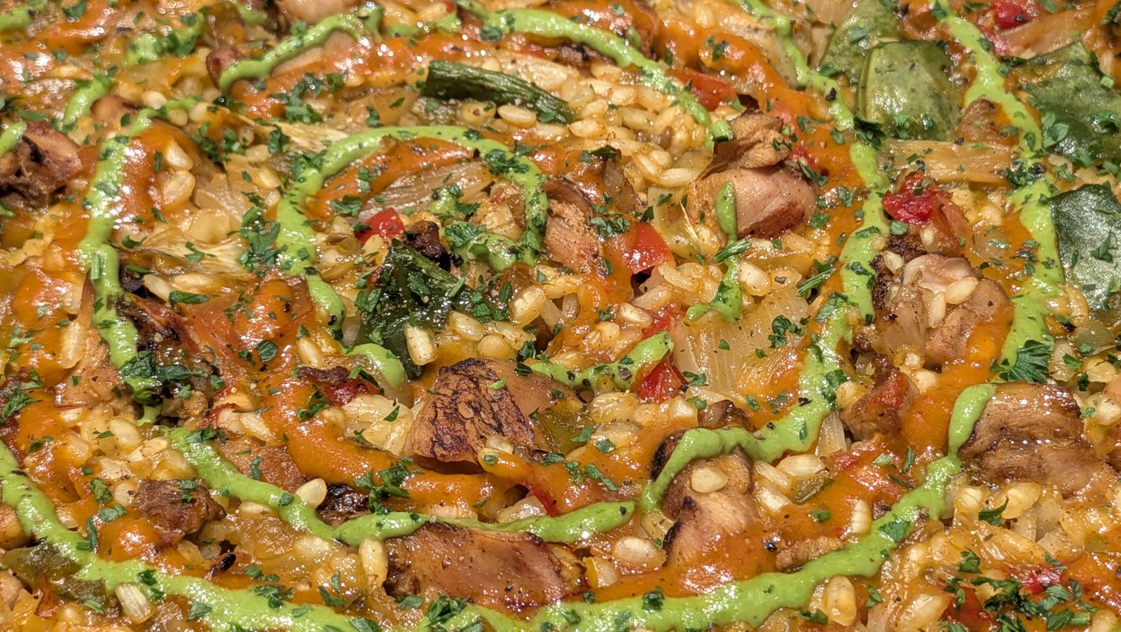 The finished Valenciana, close: rabbit, rice, green beans, the two sauces.