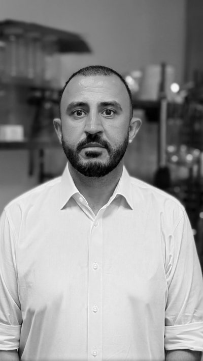 Mete Akbaba in a white shirt in the kitchen at L Campo.