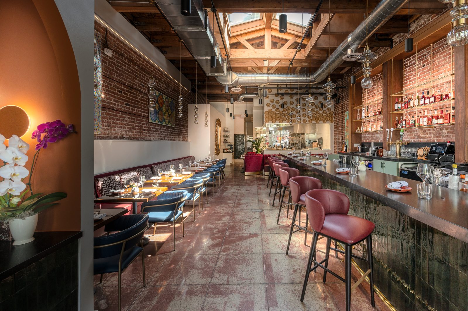 The dining room at L Campo: exposed brick, a long bar, red leather stools and a skylight over the tables.